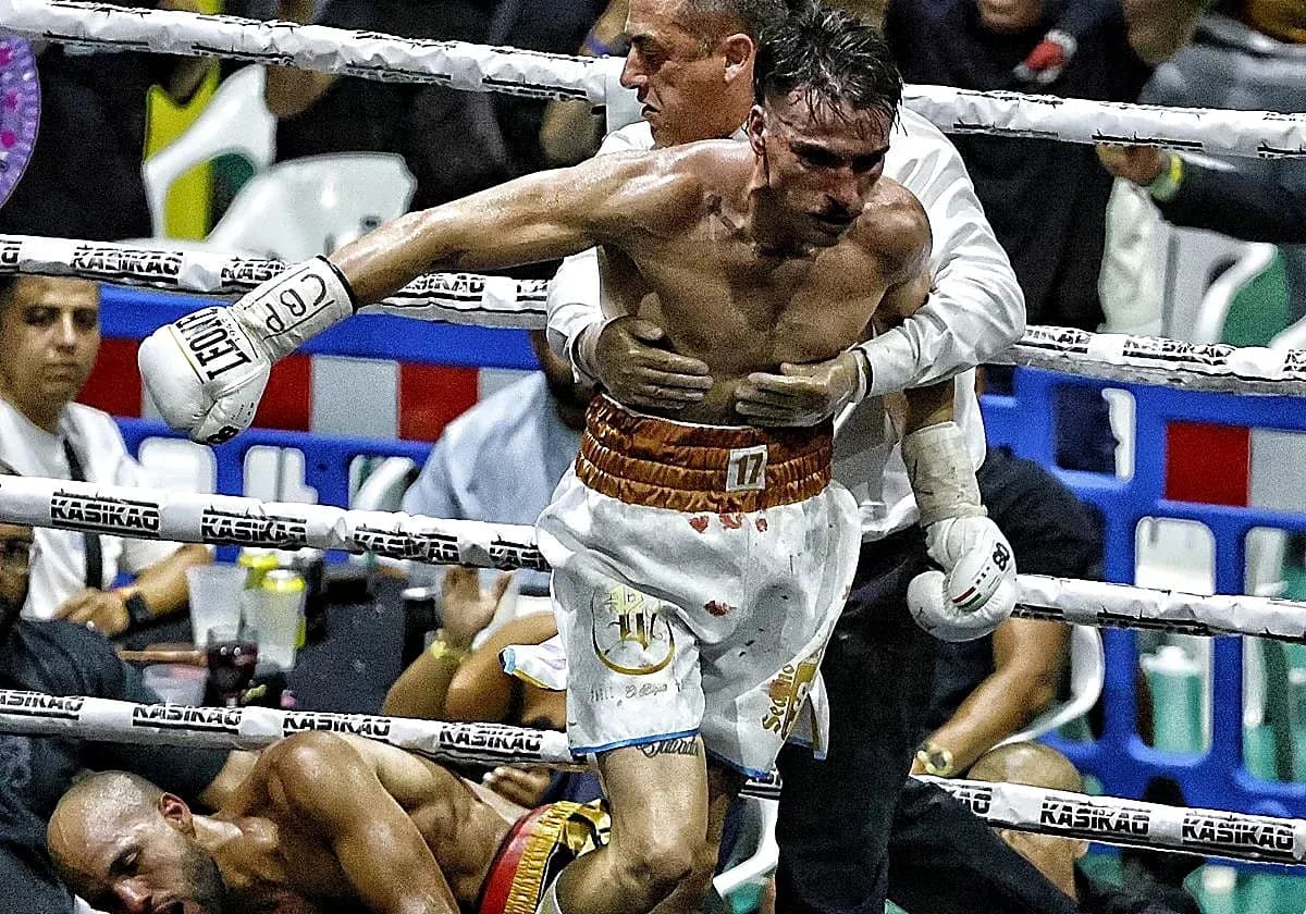 Boxer being assisted after a knockout in the ring