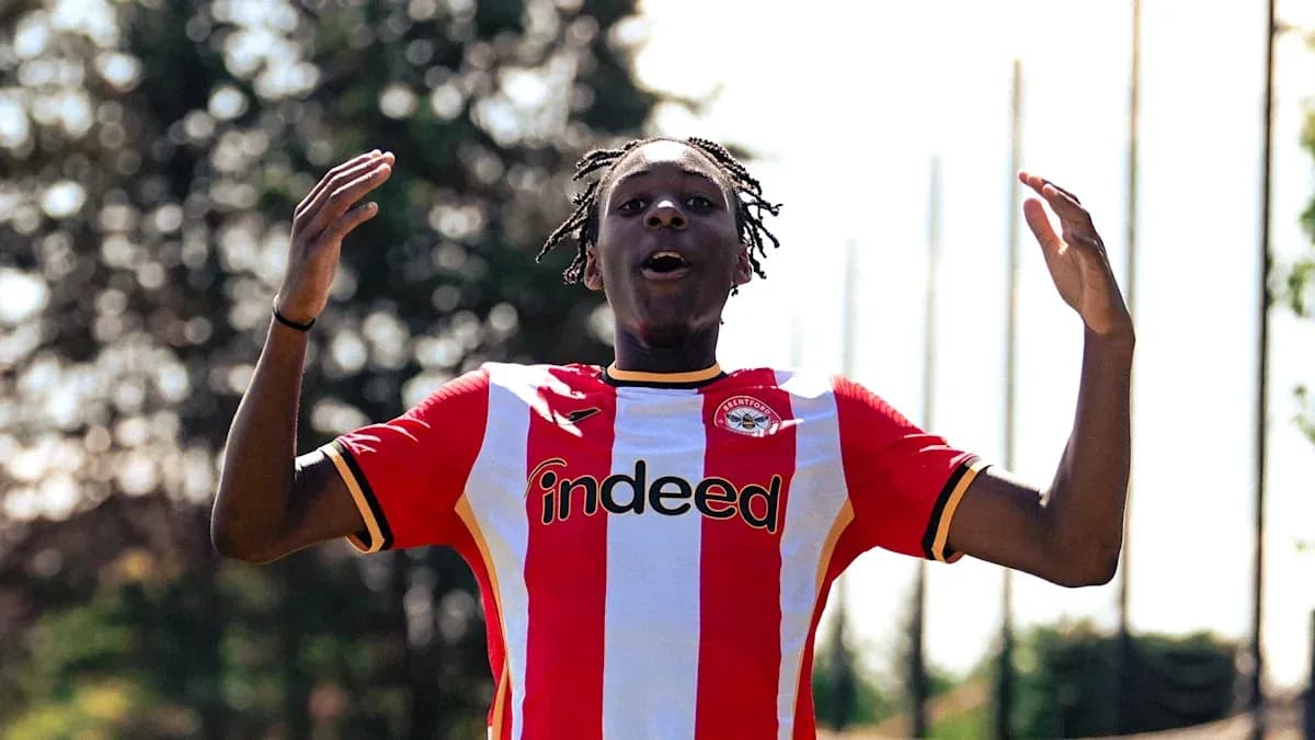 Futbolchi Brentford formasida qo'llarini ko'tarib turibdi
