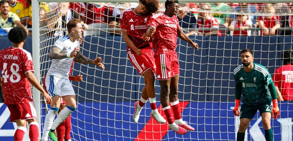 Liverpool players jumping to head the ball in match