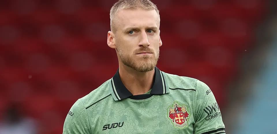 Goalkeeper wearing green kit during match preparation