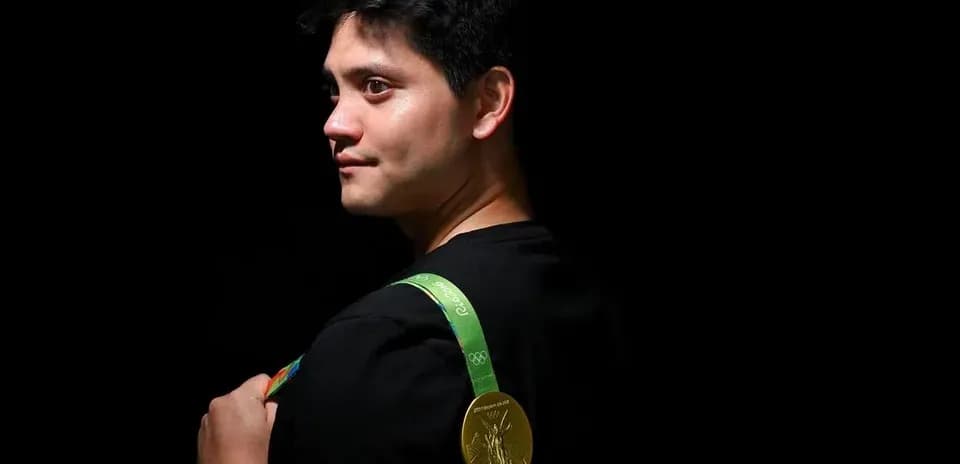 Athlete holding Olympic gold medal on shoulder