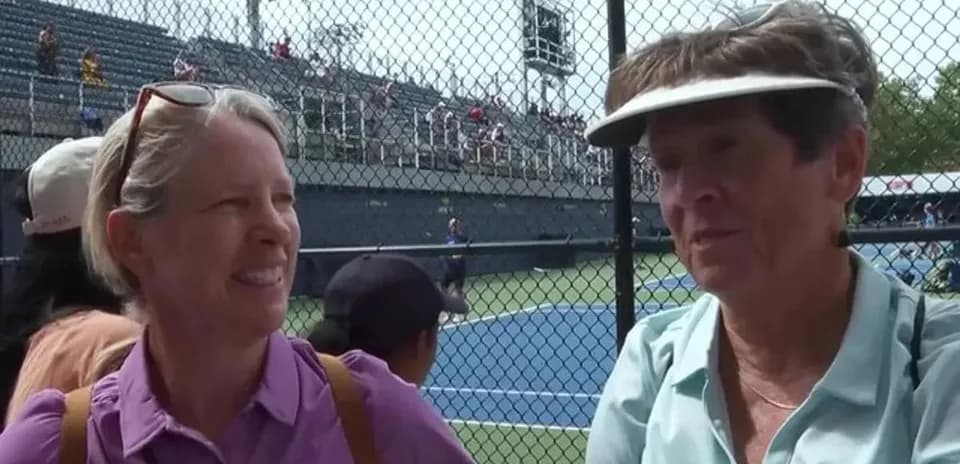 Two women talking at a tennis match