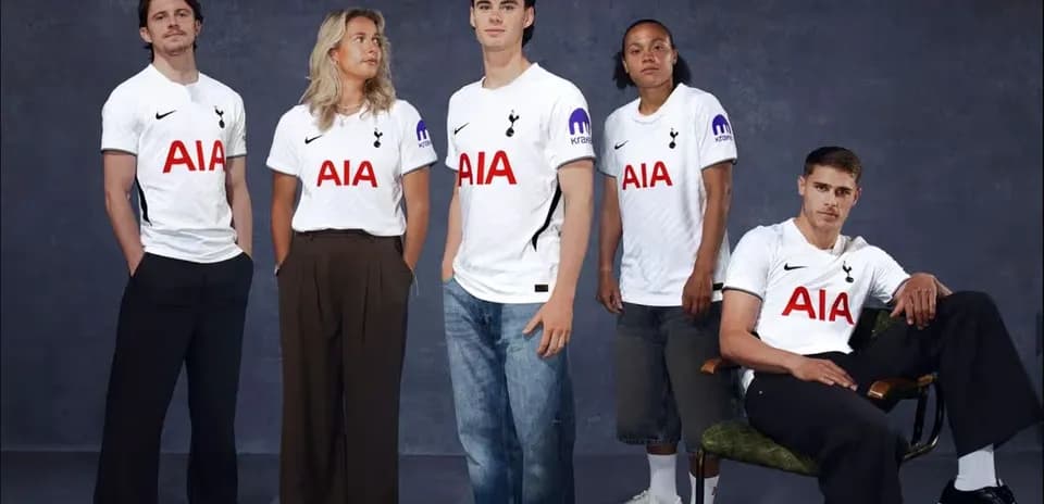 Five individuals wearing Tottenham jerseys posing together