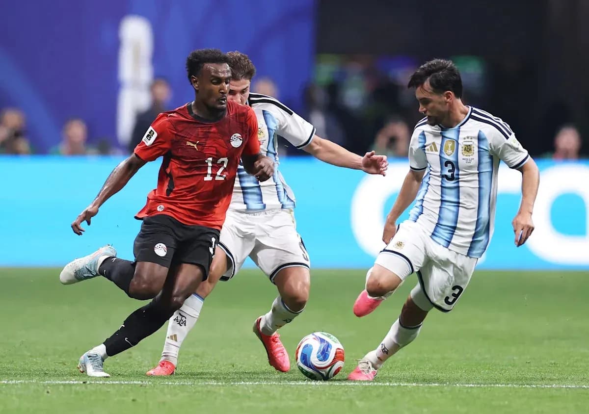 Egyptian player dribbling past Argentine defenders