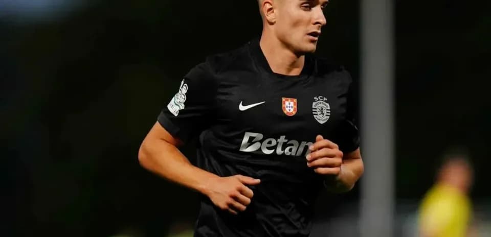 Futbolchi qora forma bilan maydonda yugurmoqda