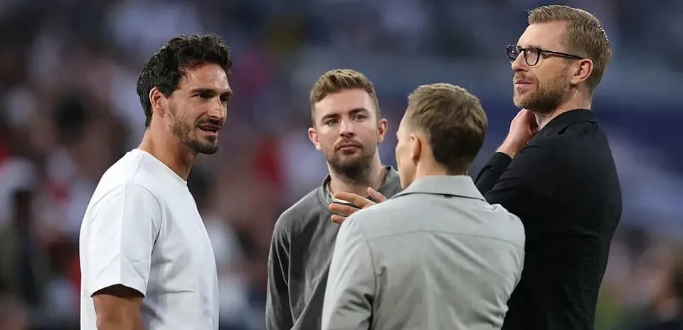 Four men talking on the pitch before the match