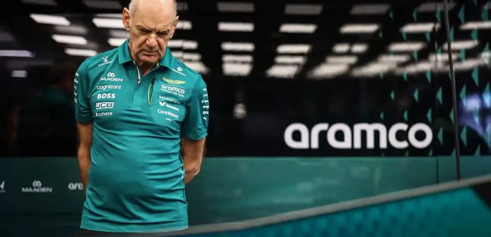 Team member in Aston Martin uniform examining equipment