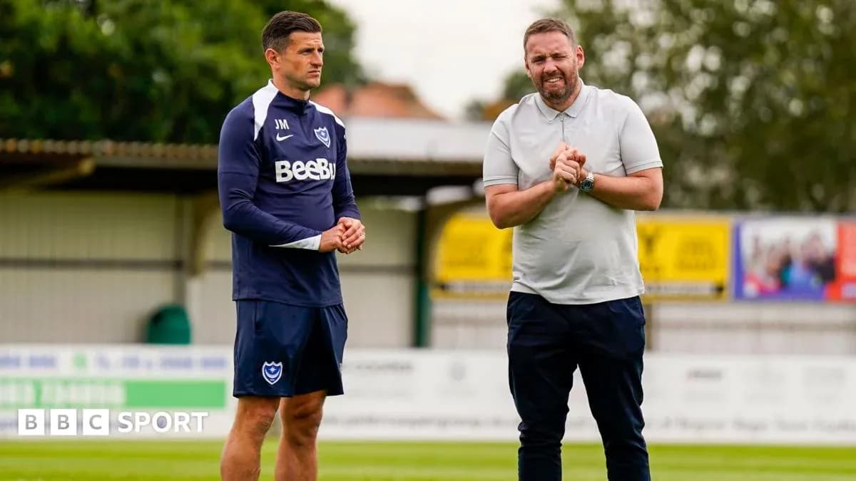 Two coaches discussing on the training ground