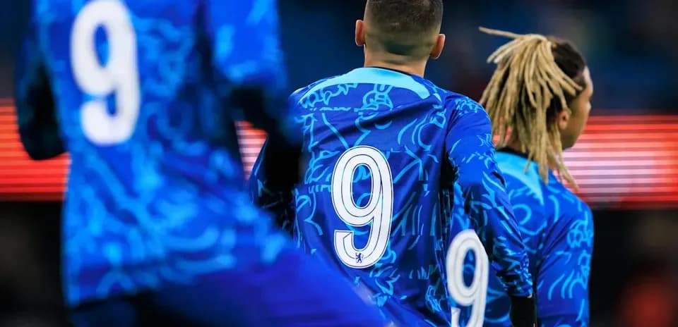 Futbolchilar ko'k formada, raqami 9 ko'rsatilgan