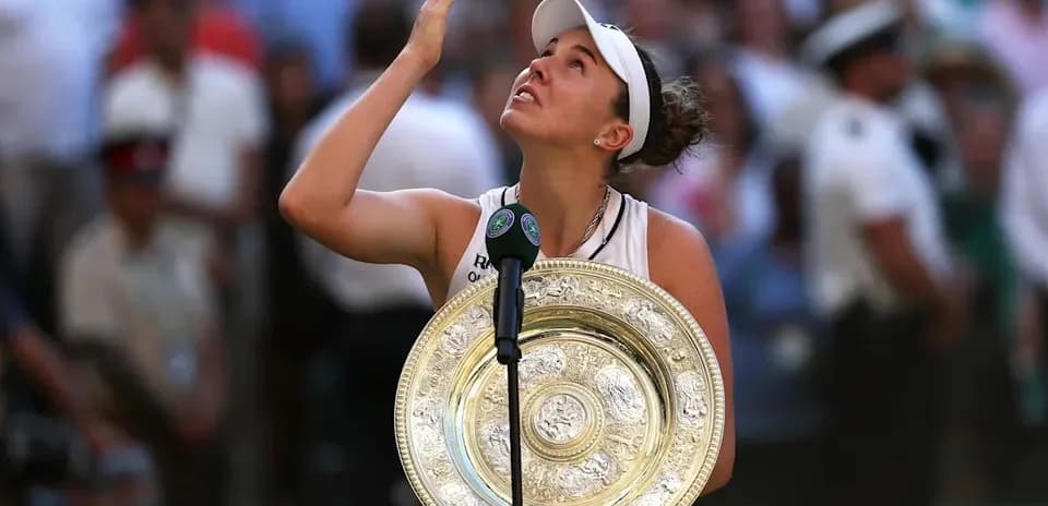 Tennis player holding trophy and looking up