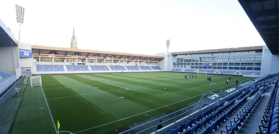 Stadium with players warming up on the pitch