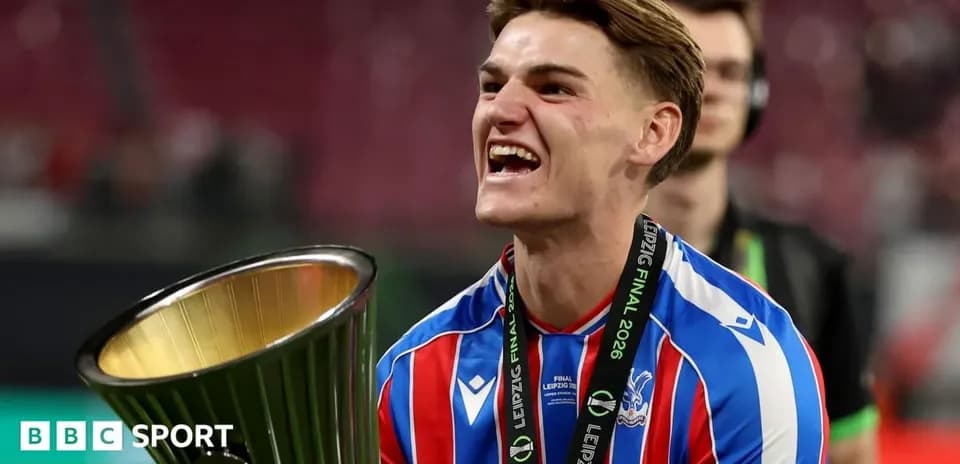 Futbolchi kubok bilan g'alaba qozonayotgan