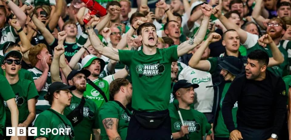 Hibernian fans cheering in the stands with a megaphone