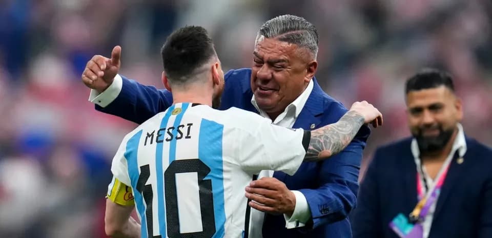 Lionel Messi embracing a man in formal attire