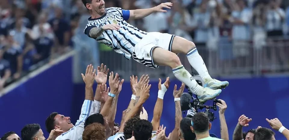 Messi being lifted by teammates after victory