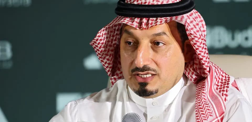 Shirted man speaking into microphone at conference