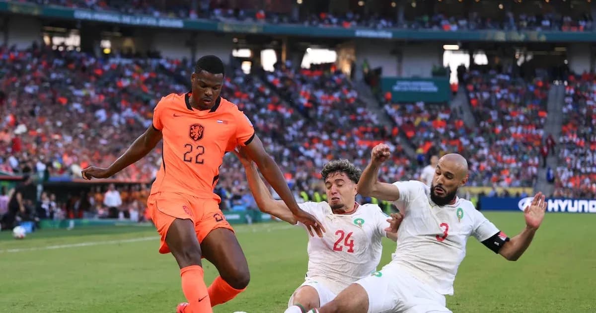Holland player dribbling past two Moroccan defenders