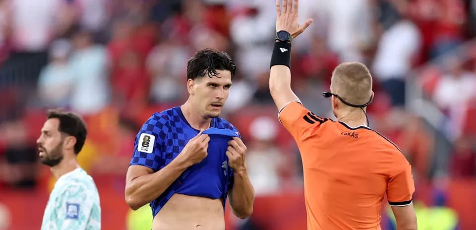 Referee showing a card to a player on field