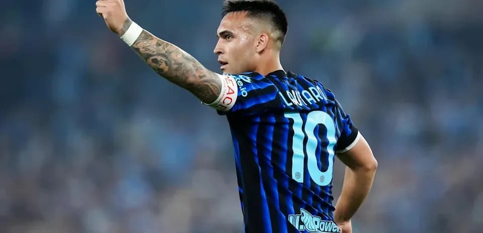 Futbolchi maydonda qo'lini ko'tarib turibdi