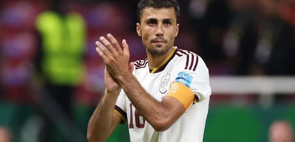 Futbolchi maydonida qo'lni qarsak bilan qarsaklab turibdi
