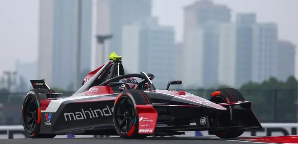 Mahindra racing car on track with city skyline