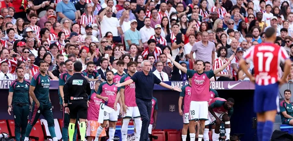 Coaching staff and players on sidelines during match