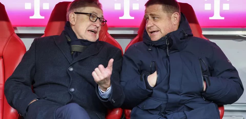Two men conversing on the bench during match