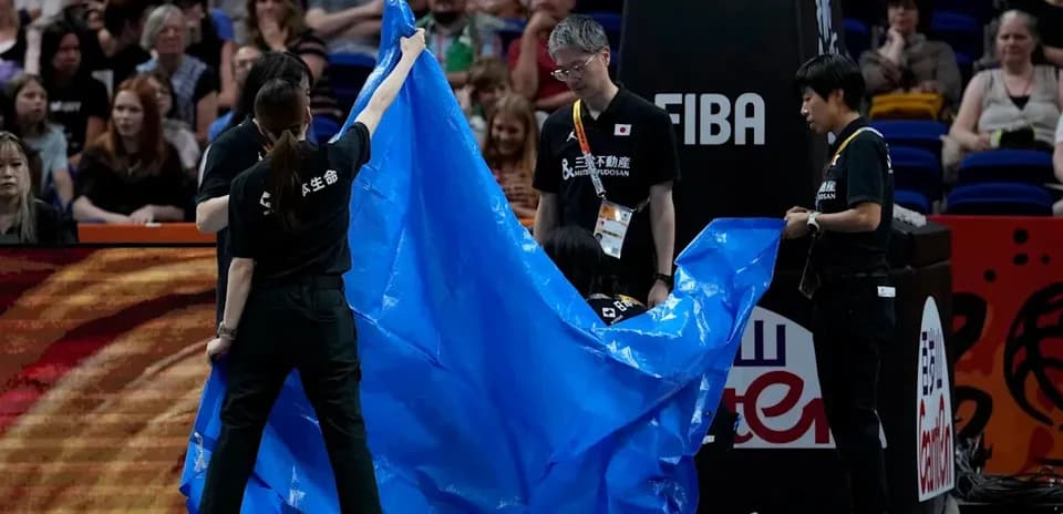 Staff covering court with blue tarp during game