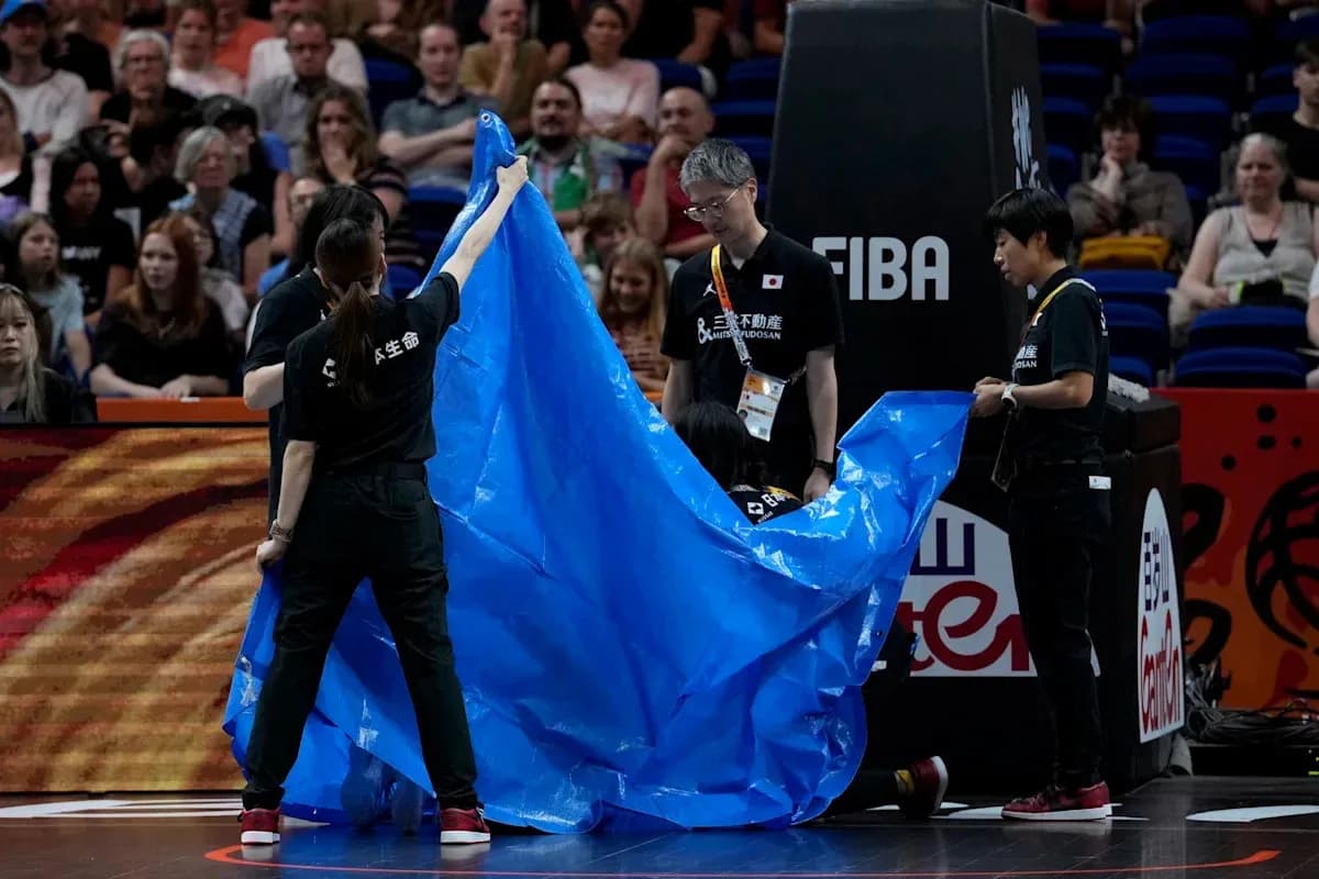 Staff covering court with blue tarp during game