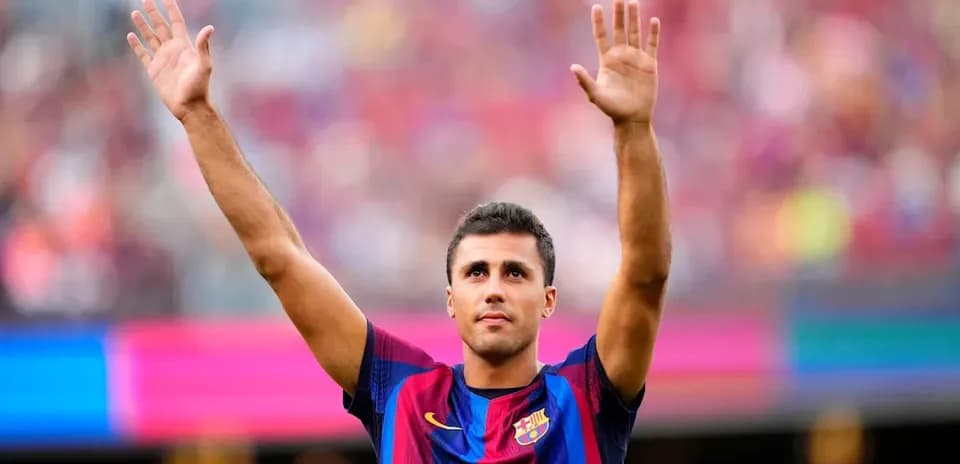 Futbolchi Barcelona formasida qo'lini ko'tarib turibdi