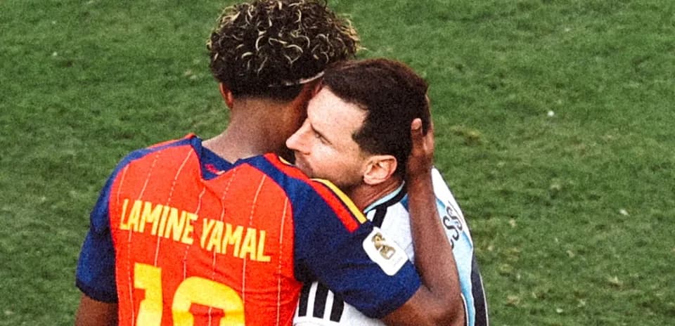Lamine Yamal and Lionel Messi embracing on field