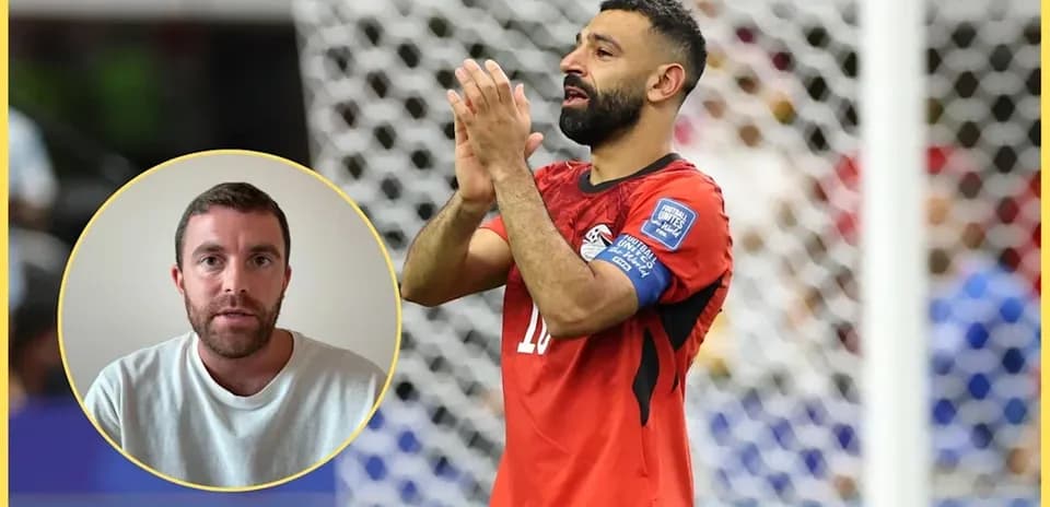 Futbolchi maydonda qo'llarini yuqoriga ko'tarib turibdi