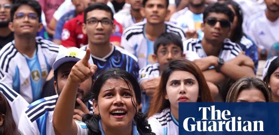 Fans watching football match, wearing Argentina jerseys