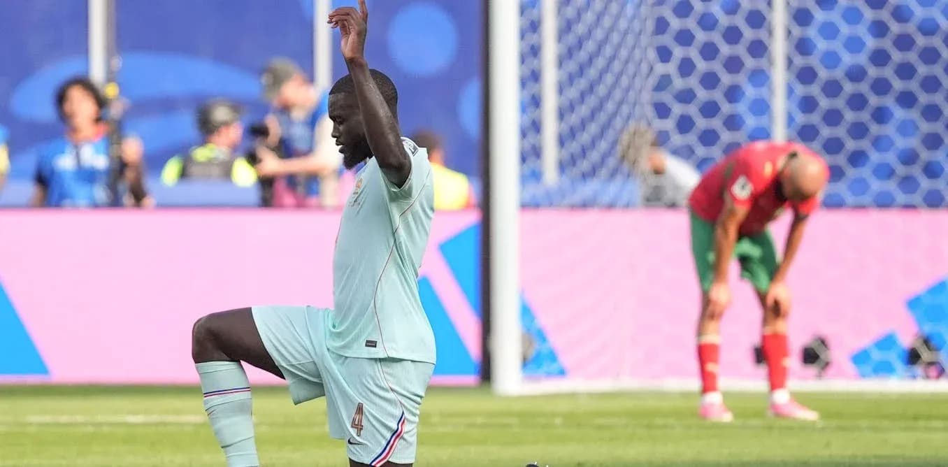 Defender kneeling on pitch during match action