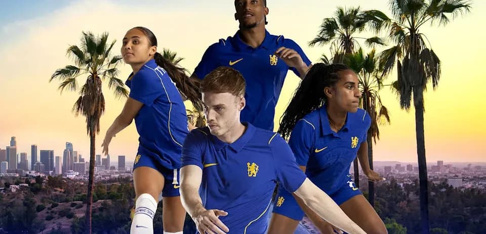 Four football players in blue kits posing outdoors