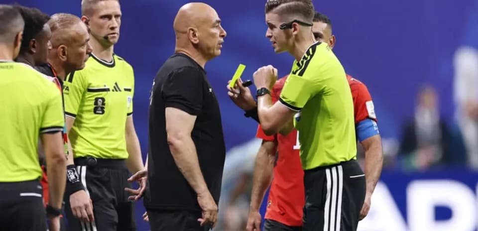 Referee discussing with coaches during match stoppage