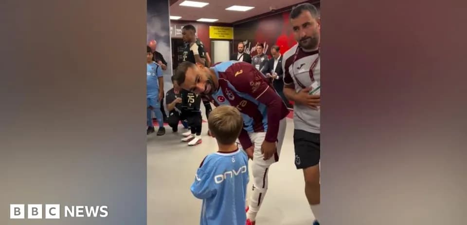 Futbolchi bolalar bilan kiyinish xonasida suhbatlashmoqda