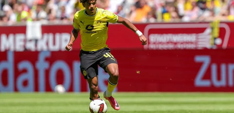 Futbolchi to'pni ushlab, maydon bo'ylab harakatlanmoqda
