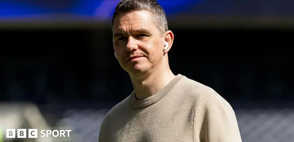 Man wearing headphones, standing at stadium