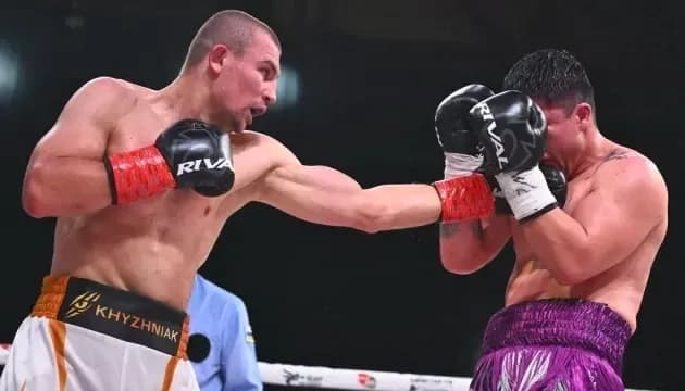 Boxer delivering punch to opponent in ring
