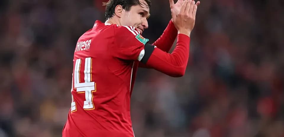 Futbolchi qizil forma kiyib, qo'l chalayapti