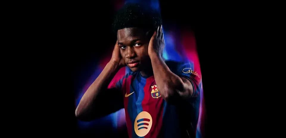 Futbolchi Barcelona formasida, qo'llarini quloq ustida tutgan