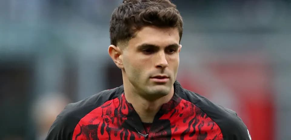 Futbolchi maydonda harakatda, qizil qora forma kiygan