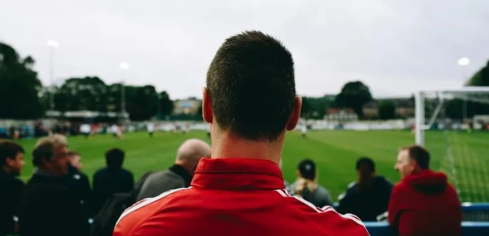 Futbol o'yinini tomosha qilayotgan odamlar