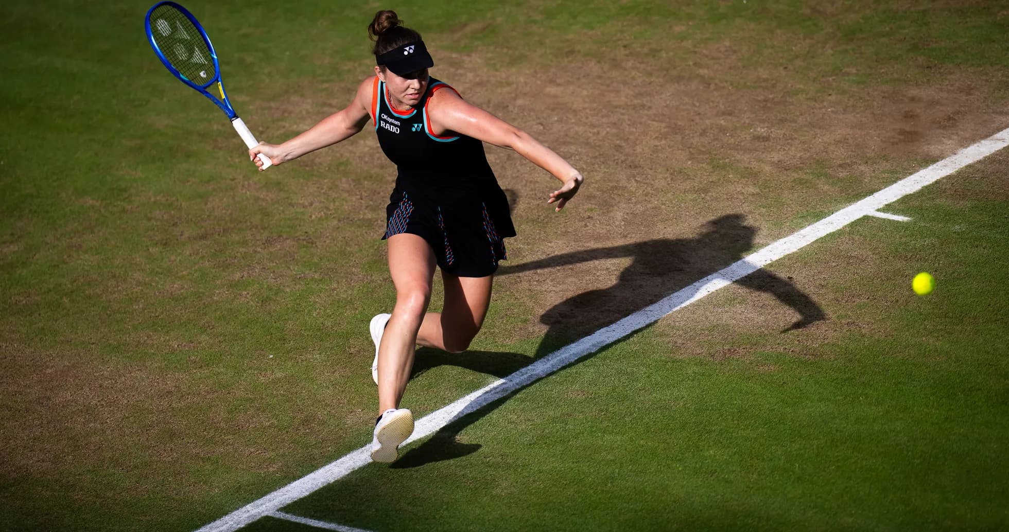 Tennis player hitting a forehand on grass court