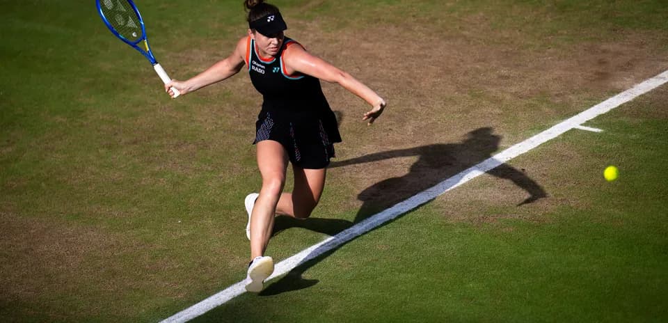 Tennis player hitting a forehand on grass court