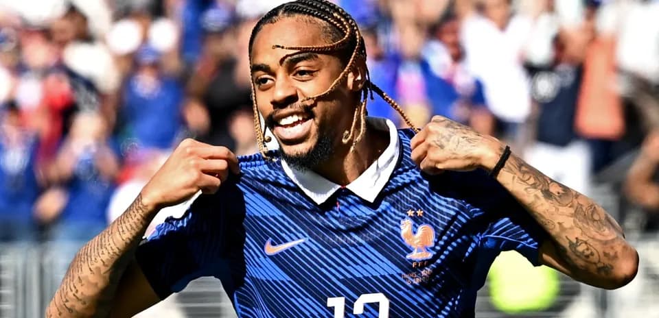 Futbolchi Fransiya formasida g'alaba nishoni ko'rsatmoqda