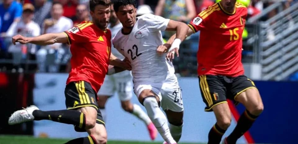 Egyptian player challenged by two Belgian defenders