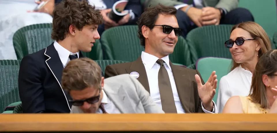 Four people seated in a box at Wimbledon