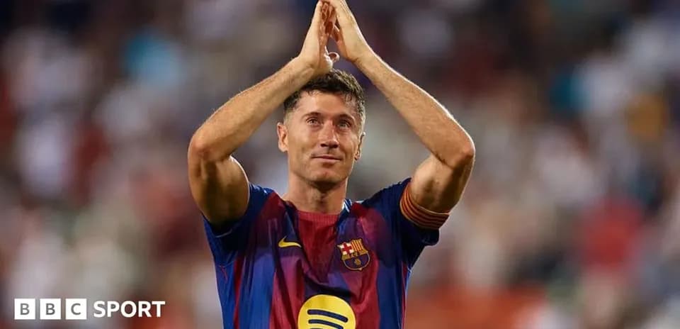 Futbolchi Robert Lewandowski stadion oldida qo'lini ko'tarib turibdi